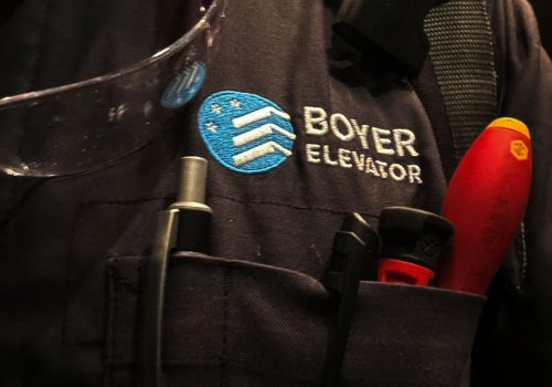 Boyer Elevator Services logo on a mechanics uniform.